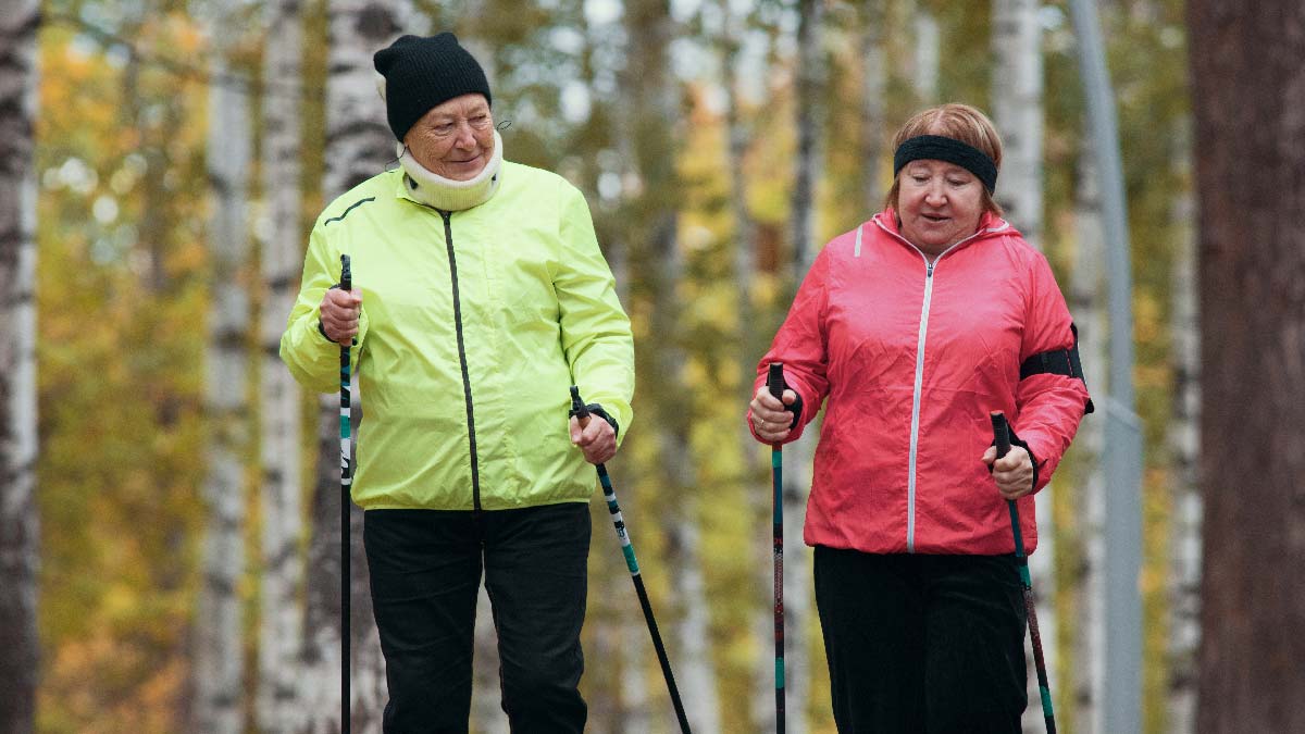 Due donne che stanno praticando il nordic wailking in un bosco